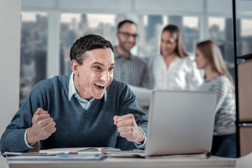 Exuberant man sitting at his laptop