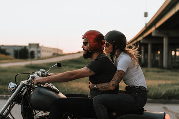 Biker couple riding down the road in the sunset