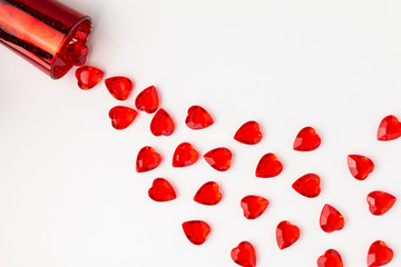 Red Jewel Hearts on White Background as if Spilling out of a Cup