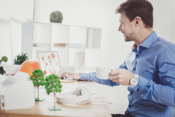 Positive nice man looking at the laptop screen