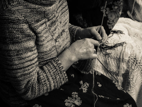 Detail of an old lady knitting.