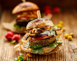 Vegetarian burgers,  homemade burger with green peas cutlet, grilled mushrooms, tomato, red onion,...