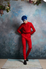Portrait of a fashionable young guy in a tap-suit and a colorful blue hairstyle