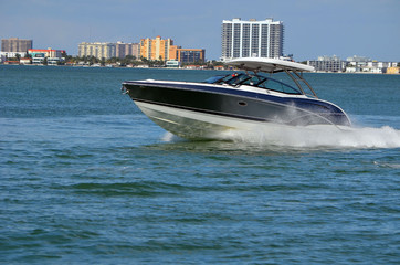 Obraz premium High-end motorboat with white fiber glass canopy on the Intra-Coastal Waterway with Miami building skyline in the background
