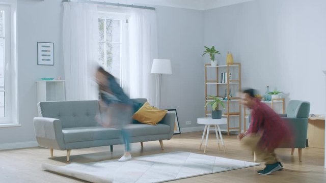 Time-Lapse: Happy Young Couple Moves into New Apartment, Arranges Furniture, Hanging Paintings, Resting after Everything is Done. Bright Modern House with Big Windows and Stylish Furniture.