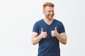 Nice job man, like it. Pleased good-looking happy male friend with ginger hair and brislte, showing...