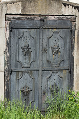Old locked heavy metal door at tomb entrance to burial crypt 