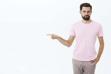 Portrait of displeased and unimpressed picky boyfriend with beard holding hand in pocket smirking...