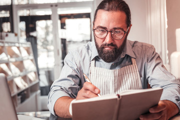 Cafe owner making important notes while working