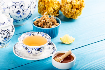 Cup of Linden Tea, Dried Linden Flowers in bowl with honey and lemon on wooden background