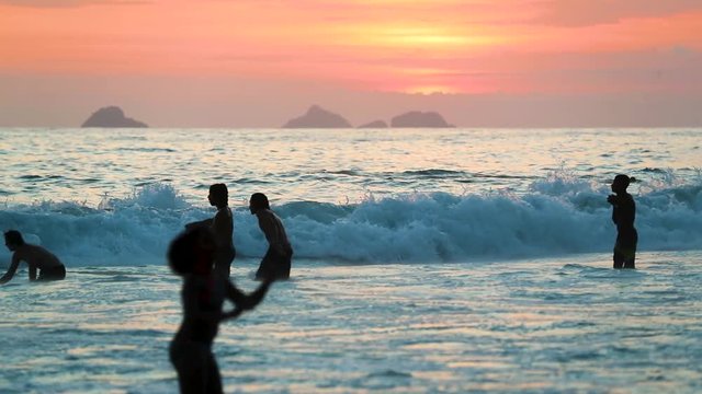 Joung man enjojing waves in sand beach on sunset, Leblon, Copacabana, Rio de Janeiro, Brazil