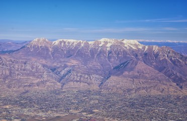 Aerial view of Wasatch Front Rocky Mountain landscapes on flight over Colorado and Utah during winter. Grand sweeping views near the Great Salt Lake, Utah Lake, Provo, Timpanogos, Lone and Twin Peaks 
