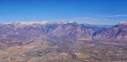 Aerial view of Wasatch Front Rocky Mountain landscapes on flight over Colorado and Utah during winter. Grand sweeping views near the Great Salt Lake, Utah Lake, Provo, Timpanogos, Lone and Twin Peaks 