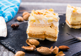 Homemade cake with whipped cream, almonds petals, toffi cream