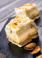 Homemade cake with whipped cream, almonds petals, toffi cream