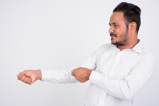 Studio Shot Of Bearded Indian Businessman Pulling Something