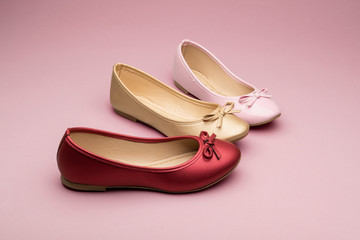 Flats color rojo, dorado y rosa sobre fondo de color para catalogo de zapatos, moda primavera verano