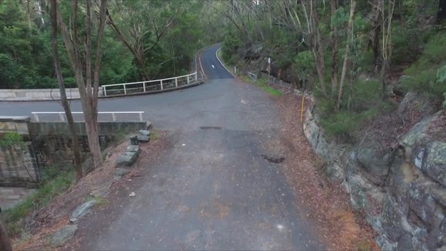 Viewed from an accending perspective we see the dense bushland that hides the sandstone bridge built by hand from the very valley walls on this mountain road.