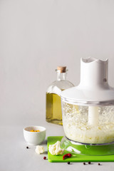 Blender bowl with freshly prepared cauliflower rice and spices, selective focus