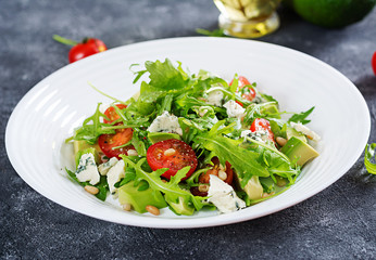 Dietary salad with tomatoes, blue cheese, avocado, arugula and pine nuts.