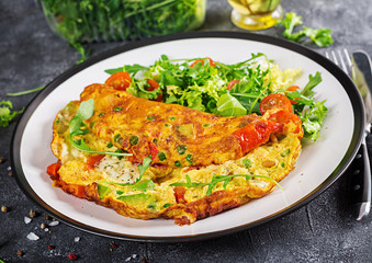 Breakfast. Omelette with tomatoes, avocado, blue cheese and green peas on white plate.  Frittata - italian omelet.
