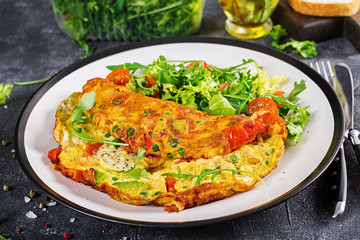 Breakfast. Omelette with tomatoes, avocado, blue cheese and green peas on white plate.  Frittata - italian omelet.