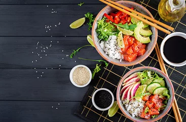 Garden poster meal dishes Hawaiian salmon fish poke bowl with rice, avocado, paprika, cucumber, radish, sesame seeds and lime. Buddha bowl. Diet food. Top view