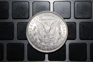 United States of America coin one silver dollar on the keyboard. US Morgan silver dollar coin 1921