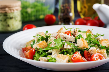 Healthy grilled chicken Caesar salad with tomatoes, cheese and croutons. North American cuisine.