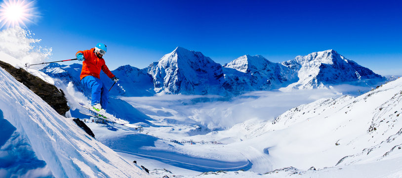 Mountaineer backcountry ski along a snowy ridge of mountains. In background blue sky and shiny sun and Ortler in South Tirol, Italy.  Adventure winter extreme sport.