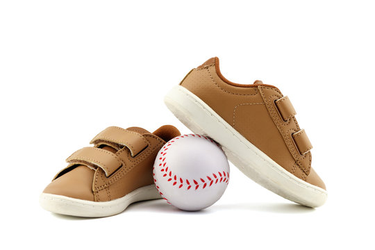 Concept encourage children to play sport, exercise for a healthy body, shoes of small baby shoes next to ball isolated on white background.
