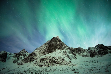 Aurora borealis explosion on snow mountain - obrazy, fototapety, plakaty