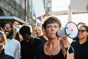 Feminist with a megaphone at a protest - obrazy, fototapety, plakaty