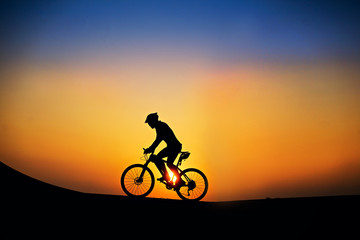 Silhouette of cyclist with mountain bike on beautiful sunset time.