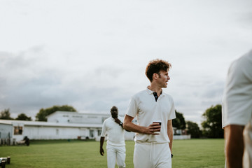 Cricket player holding a coffee paper cup