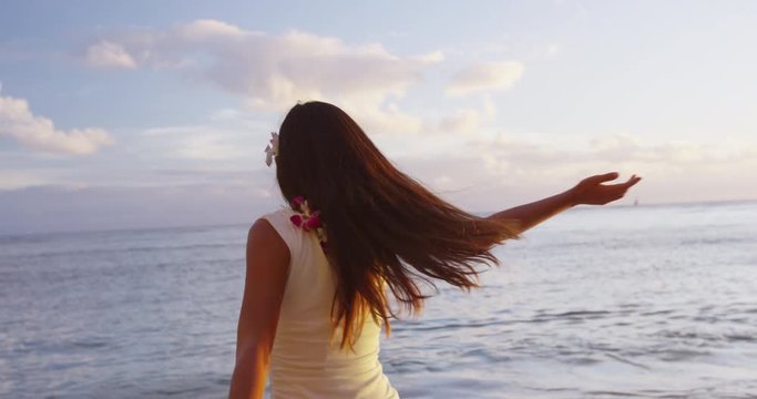 Happy carefree woman free at Hawaii beach sunset wearing flower Lei ready for Hawaiian beach Luau