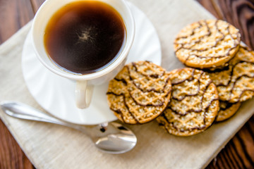 Coffee with biscuits on brown wooden background 