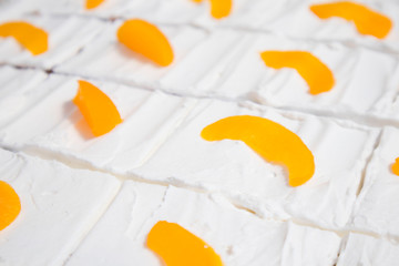 close up cakes with white cream and tangerine or orange filling, background