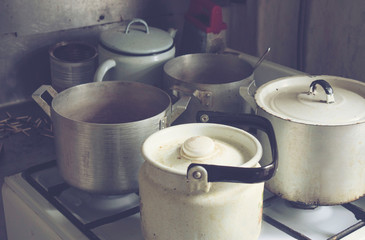 old dishes, kettle, pans on the gas burner