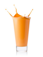Carrot or citrus smoothie or yogurt with splash in glass