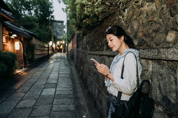 Fototapeta na wymiar local japanese lady waiting along the stone wall