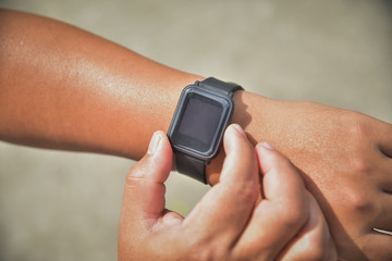 Closeup of hands and wrist with smart watch screen,smartwatch touching button and touchscreen on active sports activity
