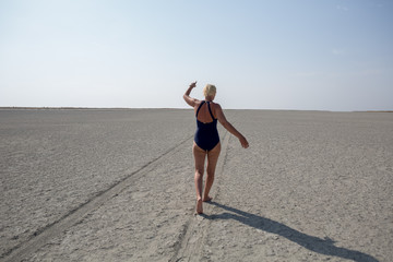 Road in the desert, walking woman