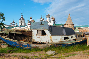 Old fishing boat on the shore against the background of the Transfiguration of the Solovetsky...
