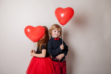 Happy kids with red heart balloon on a light background