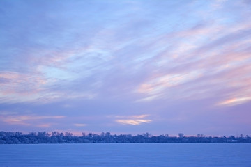 Winter rural landscape. Lake in winter. Sunset on the lake.