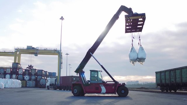 Crane Operator And Mobile Crane Machine Lifting White Bags In The Wagons.