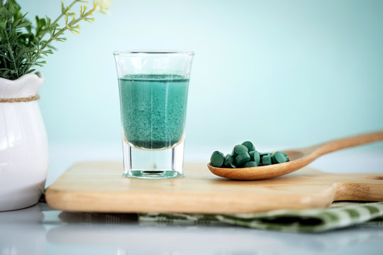 Close up a vegan blue spirulina smoothie and spirulina pills , a healthy superfood diet and detox nutrition concept