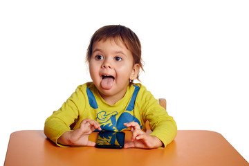 Adorable little child using phone at desk, isolated on white background, shot in studio