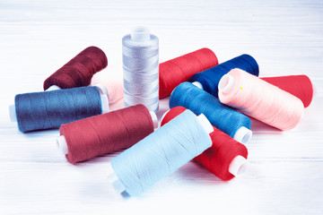 Many colorful threads lying on white table